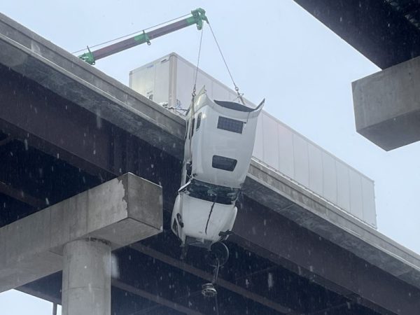 The driver of a semitrailer was rescued from his cab after a highway crash left it partially hanging over a bridge in West Virginia